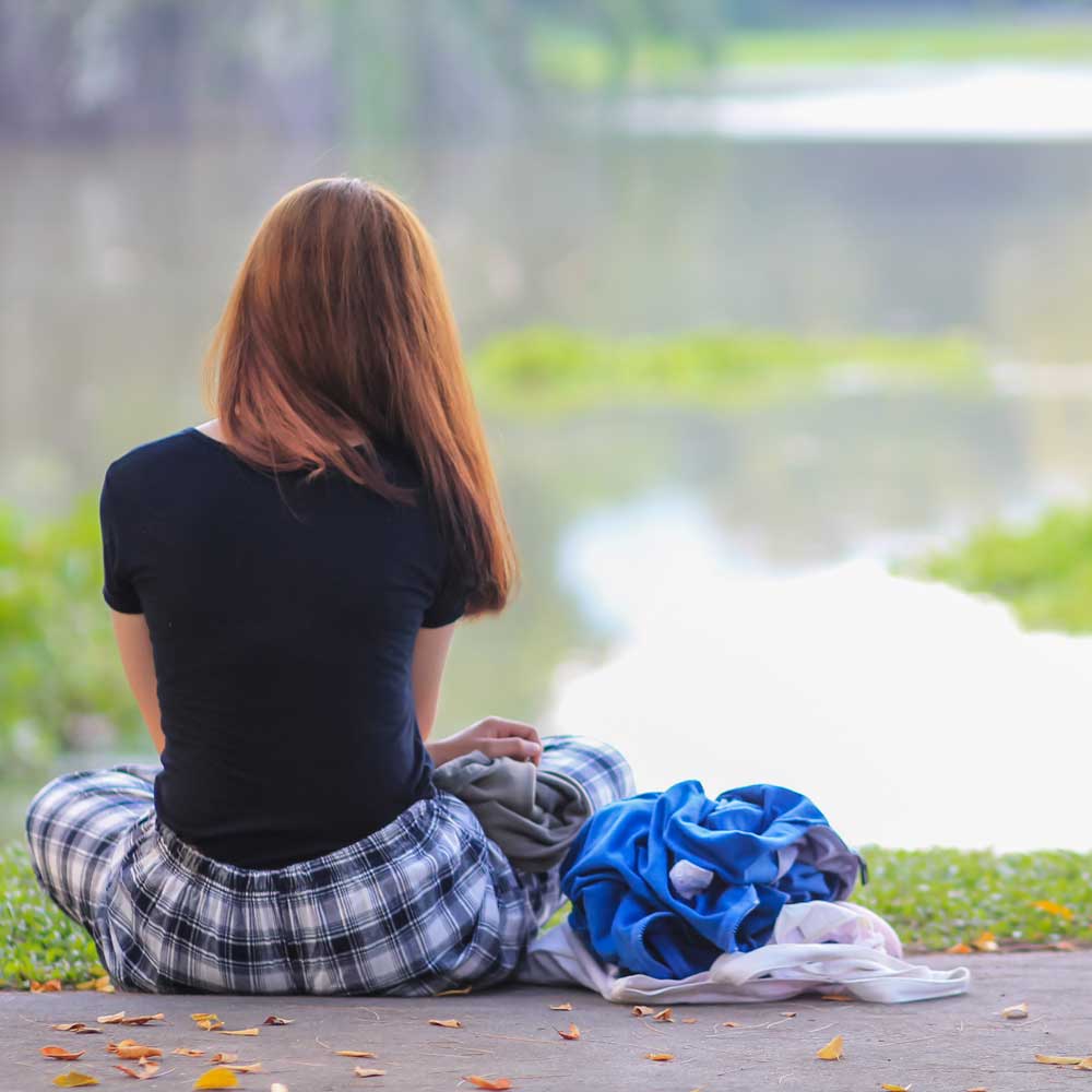 A teenage girl from teh back looking lonely